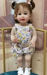 Detail of reborn doll wearing floral romper and white sandals with daisy hair clips