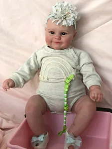 Detail of Maddie reborn doll showing realistic 3D skin texture and rainbow onesie