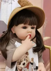 Close-up of realistic reborn doll with brown pigtails, bear print shirt and straw hat