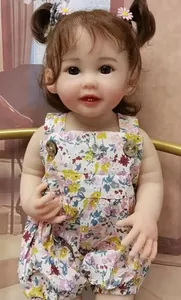 Detail of reborn baby doll with brown pigtails, floral romper and daisy hair clips