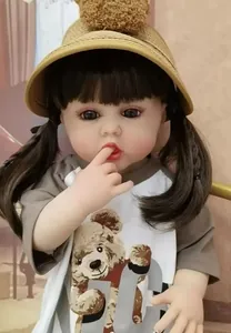 Close-up of lifelike reborn baby doll featuring brown pigtails and a knitted pom-pom hat