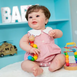 50cm lifelike reborn baby doll with blue eyes and pink dress on a soft blue shelf