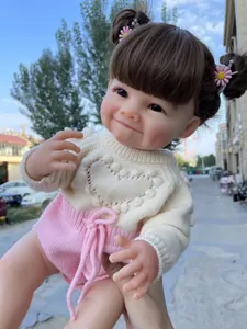Gros plan extérieur d'une poupée reborn de 55cm en pull rose et pantalon en maille