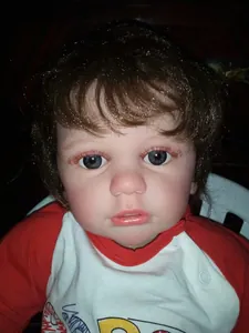 Close-up of 60cm reborn baby boy doll featuring hand-painted skin and blue eyes