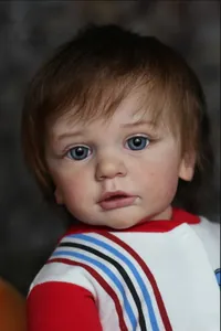 Close-up of realistic reborn boy doll featuring 3D skin texture and vivid blue glass eyes