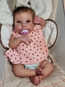 Detail of 50cm lifelike reborn doll wearing pink ladybug bib and magnetic pacifier