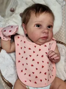 Close-up of lifelike 50cm reborn baby doll with detailed skin and pink ladybug bib
