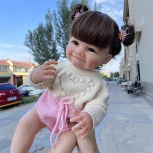Poupée Reborn réaliste de 55cm avec fossettes, pull à cœur et pinces à cheveux roses