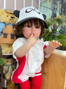 Muñeca realista con piel 3D y gorro de panda sentada junto a un gran oso de peluche