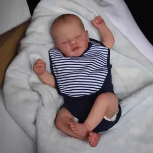 Realistic 19-inch sleeping reborn baby doll in navy outfit on blue plush blanket