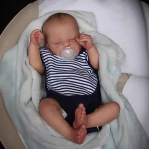 Realistic 19-inch sleeping reborn baby doll in blue striped outfit on soft bedding