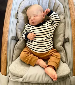 Gros plan détaillé d'une poupée reborn réaliste en tenue rayée reposant dans un transat
