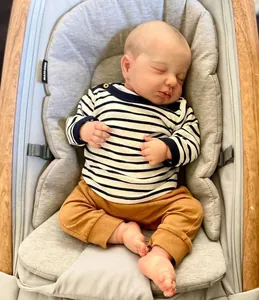 Détail de la poupée Reborn endormie avec haut rayé bleu placée dans un transat bébé
