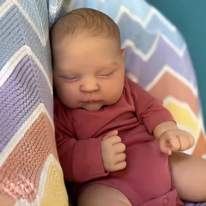 Lifelike 3D painted reborn baby doll Peaches sleeping in pink bodysuit on knit blanket