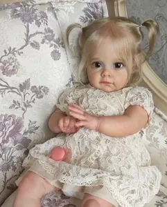 Detail der Reborn-Puppe Maggi mit blonden Zöpfen im Spitzenkleid und rosa Schnuller