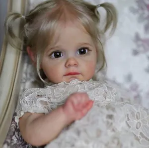 Nahaufnahme der lebensechten Reborn-Puppe Maggi mit blonden Zöpfen und Spitzenkleid