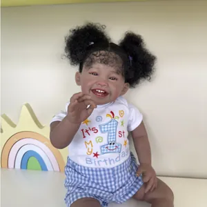 Reborn baby doll Mila in first birthday outfit with black space buns and a joyful smile