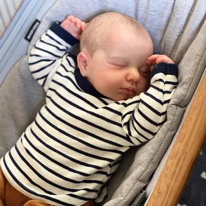 Poupée réaliste LOULOU endormie avec tenue rayée sur un transat pour bébé gris