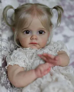 Nahaufnahme der Reborn-Puppe Maggi mit blonden Zöpfen und feinen Spitzendetails am Kleid