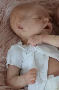 Détail d'une poupée Reborn dormante de 18 pouces avec cheveux bruns et body blanc