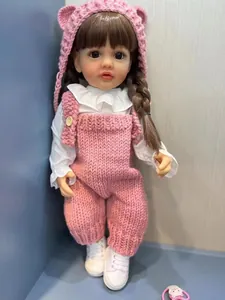 Détail d'une poupée reborn de 55 cm avec bonnet rose en tricot et chemise à volants