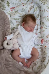 Close-up of sleeping Rosalie reborn doll with realistic skin texture and white romper
