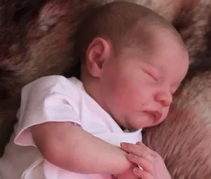 Nahaufnahme der schlafenden Levi Reborn-Puppe mit realistischer Haut auf Plüschmatte