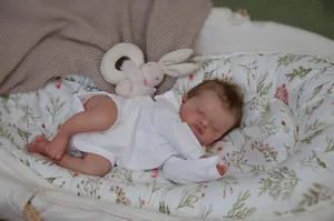 Realistic 48cm sleeping reborn baby doll in white bodysuit and floral baby nest