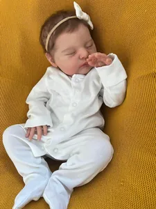 Close-up of 19-inch sleeping reborn doll with realistic skin texture on yellow background