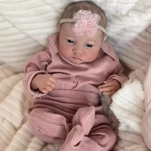 Realistic 49cm Levi reborn baby doll in pink ribbed romper with floral headband on white soft mat