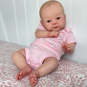 Realistic 19 inch Juliette reborn baby doll in pink romper on floral bedding