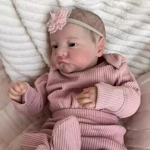 Realistic 49cm Levi reborn doll in pink ribbed romper with lace headband on plush cushion
