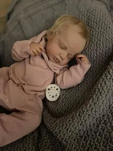 Close-up of 49cm reborn baby doll Loulou with realistic 3D skin texture and pink hoodie