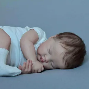 Realistic 19 inch Ashia reborn baby doll sleeping in white outfit on blue background