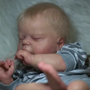 Lifelike 55cm reborn baby doll with soft skin and striped outfit on plush blanket