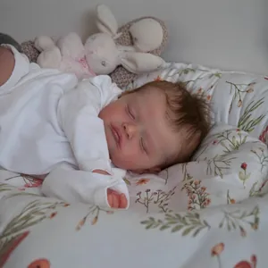 Realistic 48cm reborn baby doll Rosalie in white romper sleeping in floral nest