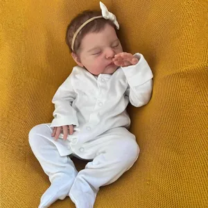 Realistic 19 inch reborn baby doll sleeping in white outfit on yellow knit blanket