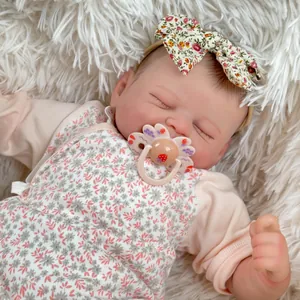 Nahaufnahme von Reborn-Puppe mit Blumen-Stirnband auf weißem Plüsch-Hintergrund
