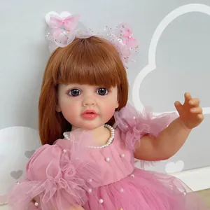 Close-up of reborn doll with auburn hair wearing pink lace dress and pearl necklace