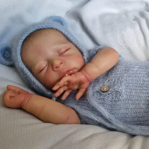 Realistic 18-inch reborn baby doll Jude sleeping in a blue knitted bear outfit