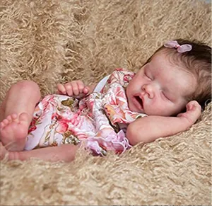 Macro detail of a sleeping newborn reborn doll in floral pink outfit on plush blanket