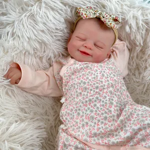 Realistische 19-Zoll-Reborn-Puppe im rosa Blumenoutfit schlafend auf weißem Plüsch