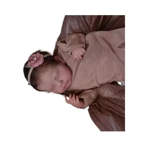 Sleeping 19-inch reborn baby doll Loulou with dark hair and a sequin flower headband
