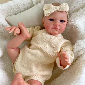 20 inch lifelike reborn baby doll with visible veins and cream knit outfit on soft rug