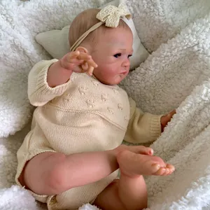 Lifelike 20-inch newborn baby doll in white knit romper with visible skin details