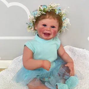 50cm Harper reborn doll with blue knit outfit and flower headband on white rug