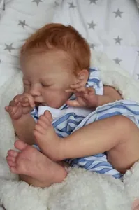 Close-up of 19-inch reborn baby doll August with realistic skin texture and blue romper