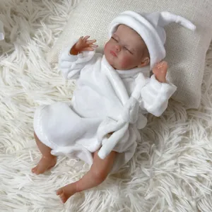 Sleeping 10-inch reborn baby doll in soft white plush bathrobe and matching sleep hat