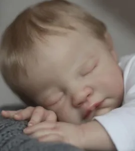 Close-up of realistic newborn reborn doll sleeping with hand-painted skin details