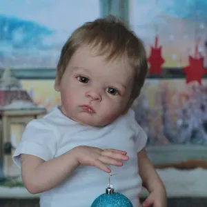 Poupée bébé reborn réaliste de 55cm avec yeux verts dans un décor d'hiver
